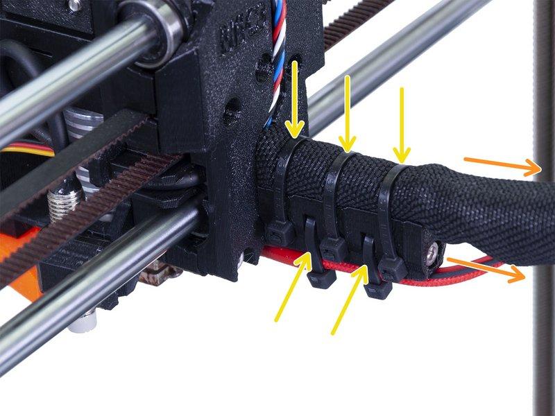 Using an Allen key release the M3x40 screw and open the door. Release two M3x10 screws and remove the extruder-cable-clip.