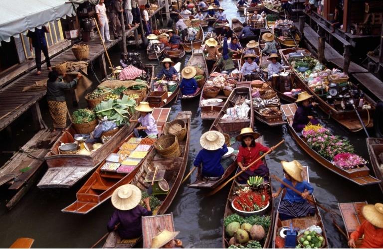 venditori ambulanti intenti nelle loro attività quotidiane, con le loro barche colme di frutta, verdura, thè, pesce e carne.