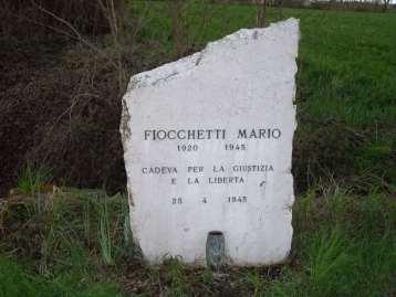 Alla Memoria di Fiocchetti Mario Si tratta di un cippo in marmo bianco con epigrafe in rilievo.