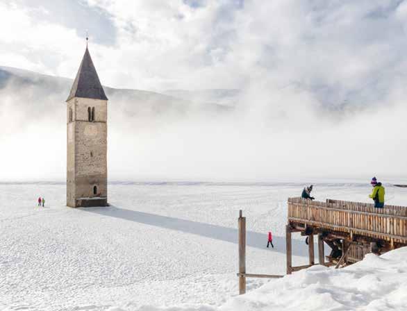 Meran In inverno il ghiaccio abbraccia scricchiolante il campanile sommerso nel lago di Resia, mentre le montagne circostanti proteggono le silenziose valli laterali offrendo uno scenario invernale