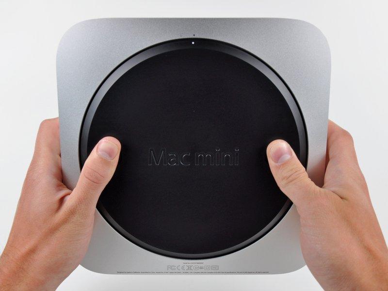 Passo 1 Installazione del coperchio inferiore nel Mac mini versione metà 2010 Posizionare i pollici negli incavi tagliati