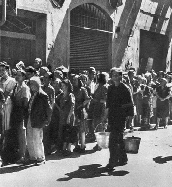 una lunga fila di persone in attesa di poter acquistare il pane Se si veniva a sapere che qualcosa arrivava in qualche negozio, al di fuori della tessera, si andava lì e si facevano chilometri e