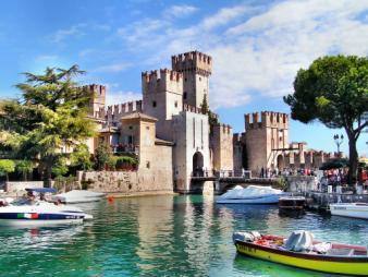 città. Non si tratta di grotte, bensì dei resti di una complessa struttura edilizia romana, che si stagliano contro l'orizzonte blu del lago e del cielo azzurro.