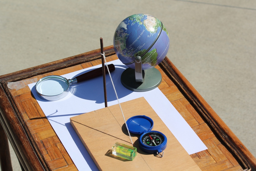 Figura 1: Gli strumenti utilizzati per la misura: tavoletta con gnomone, bussola, bolla, lente d ingrandimento e un piccolo mappamondo.