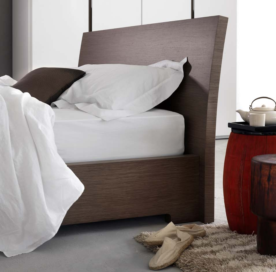 Un letto dal carattere sofisticato con testata in legno curvato abbinata al giroletto Low.
