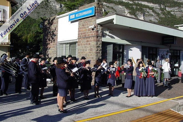 Festa sul marciapiede della stazione di Mezzolombardo con le note della Banda Cittadina.