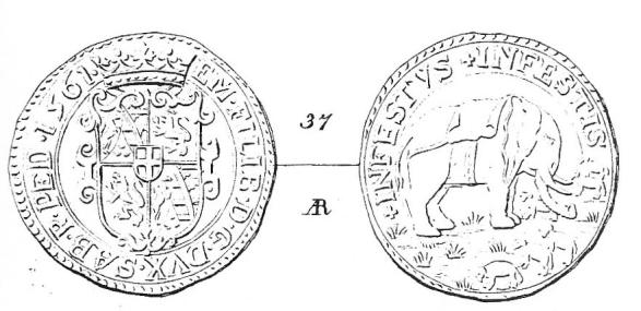 D/: Stemma inquartato con al centro lo stemma sabaudo, sormontato da corona ducale e ornato da cartocci, entro doppio cordoncino liscio.