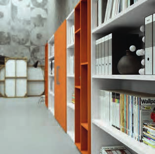 La libreria a parete è un dinamico alternarsi di geometrie e colori che si