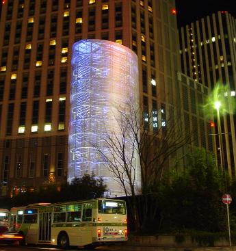 Torre dei venti Toyo Ito Avvolta in un cilindro di allumino perforato e circondata da dodici anelli al neon rivestiti da lastre