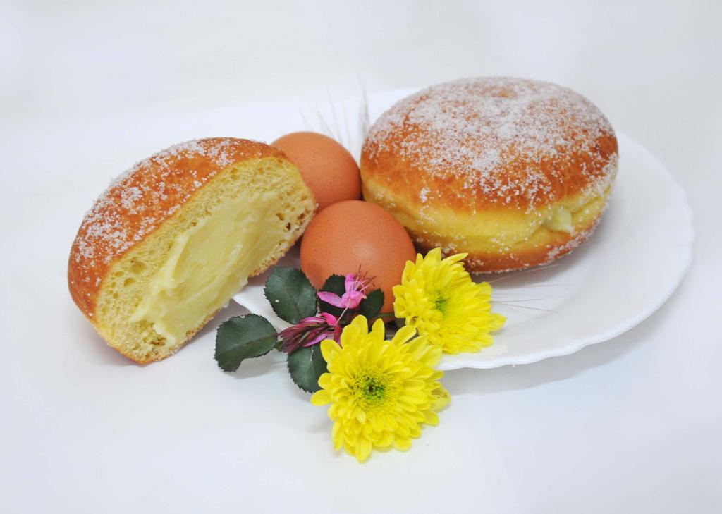 (Krapfen) Golosi bomboloni di brioche fritti, ripieni di crema pasticcera e cosparsi di zucchero a granelli. Caldi e morbidi, ideali per una colazione ricca di energia.