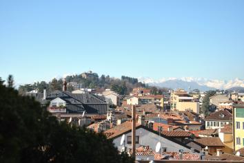 Ingresso, salone doppio con ampie vetrate panoramiche ed elegante camino in marmo, affaccio sull esclusivo terrazzo di 70 mq. con una vista che spazia dal centro storico alla catena delle Alpi.