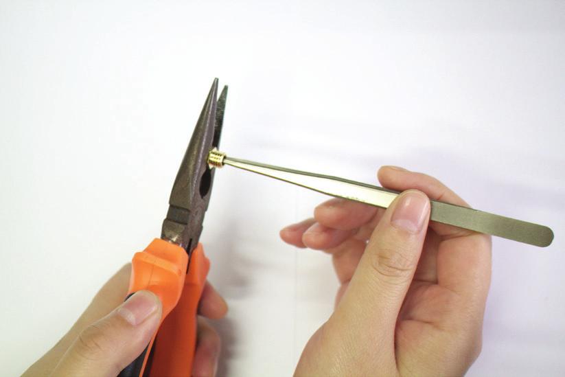 Tenete fermo l ugello con un paio di pinze e rimuovere i residui del filamento dall ugello con la pinzetta.