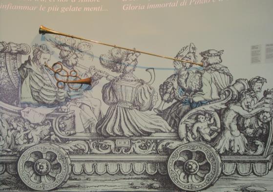Nella prima sala della Mostra puoi vedere un disegno molto grande con due veri strumenti. Questi due strumenti si chiamano trombe. Queste trombe sono dell epoca di Monteverdi.