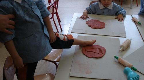 I bambini hanno manipolato l argilla e hanno lasciato impronte di mani e piedi utilizzando delle formine da mare.