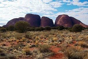 A 32 Km. a ovest di Ayers Rock si erge, nel tenue azzurro del cielo, la catena delle Olgas, anch esse un po irreali, sparse nella solitaria distesa semidesertica.