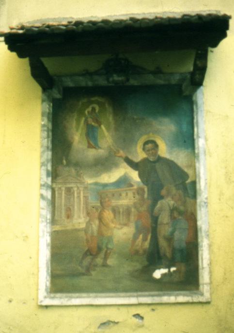 VIA GIRARDELLI PROPRIETA' : DIMENSIONI : AFFRESCO DESCRIZIONE : Situato nel cortile interno della casa, è riparato da un tettuccio in legno e tegole, raffigura San Giovanni Bosco che