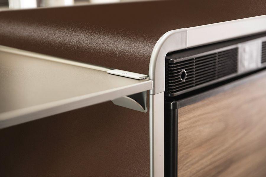 Ampliamento superficie di lavoro Al profilo del frigorifero può essere installato un prolungamento del piano di lavoro o un gancio per appendere i canovacci.