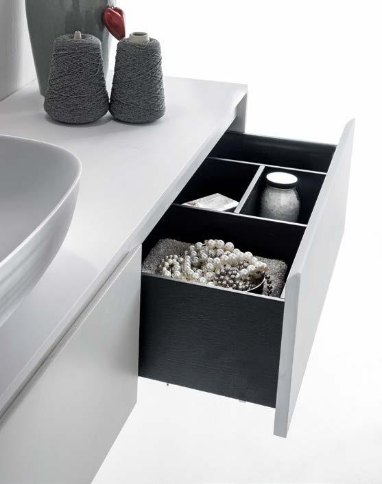 Composizione con lavabo in appoggio laterale e mobile a due cassettoni. Maniglia a gola, top in Cristalplant biobased e cassetti interni opzionali in legno, con divisori.