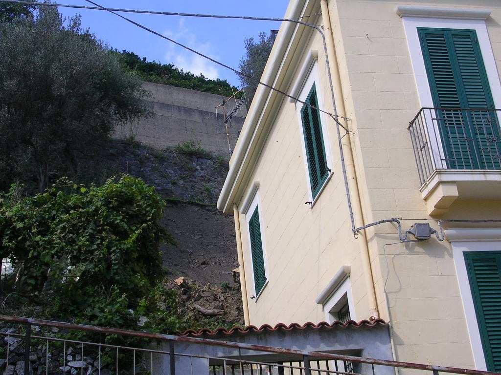 Muro in pietrame sottostante il muro in conglomerato Scalzamento della fondazione Vista valle monte dello smottamento