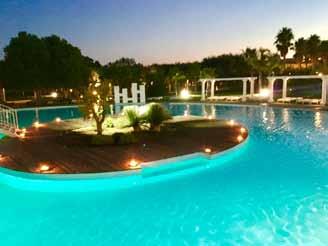 Among the hotel facilities, the swimming pool situated behind the hotel, surrounded by the green