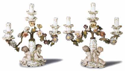 cm32x27 (ossidazioni e cadute di colore) 9-333 488 489 Coppia di candelabri a tre fiamme in porcellana decorata in oro e lavorata con putti e fiori. Francia, fine del sec.