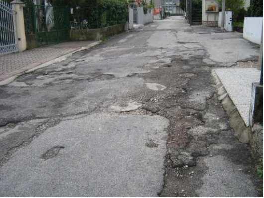 Siepi e rami sporgenti, richiesta manutenzione e un cartello stradale che invade la carreggiata. Manutenzione eseguita.