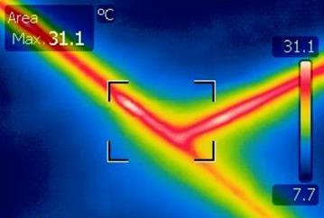 Particolare termografico di una curva in acciaio di una condotta per riscaldamento di un edificio civile e individuazione di una dispersione di calore dovuta a mancanza di adeguato isolamento