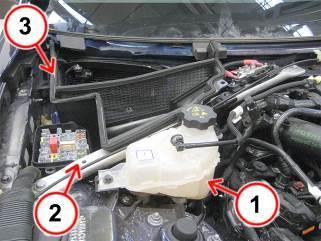 Operando nel vano motore: Svitare le viti di fissaggio e scansare a lato il serbatoio del liquido di raffreddamento motore(1).
