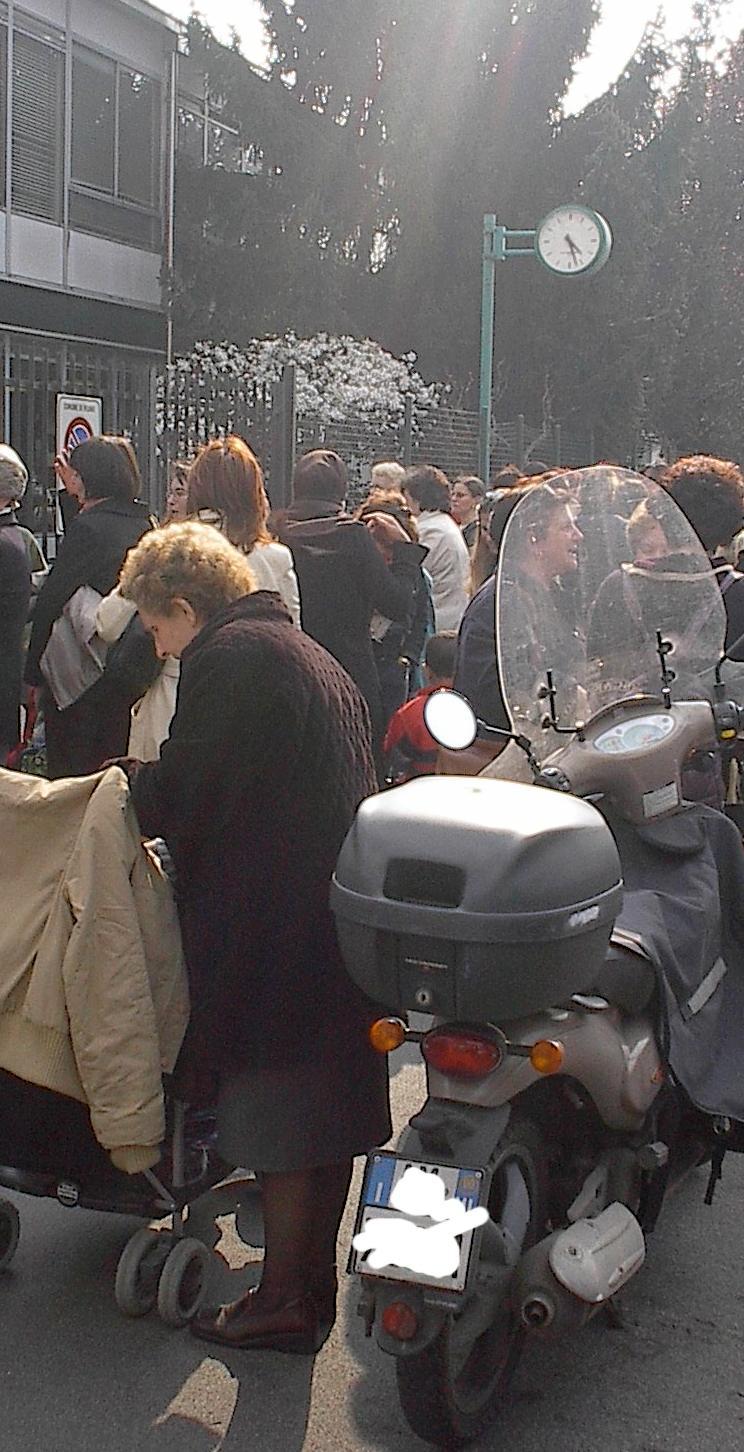 Ore 16:25 scuola elementare a Milano: veicoli in doppia fila, transito nei due sensi