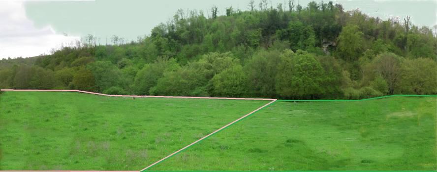 Al termine del prato ai piedi della collina in mezzo agli alberi scorre