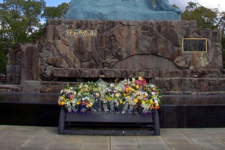 il cielo mentre il braccio sinistro è posto in posizione Figura 39 La statua con i fiori lasciati dai turisti orizzontale, verso l orizzonte.