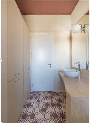 Nel progetto di Lia Lovisolo vediamo come, nel restyling di un bagno, il soffitto più scuro abbassi la quota percepita.