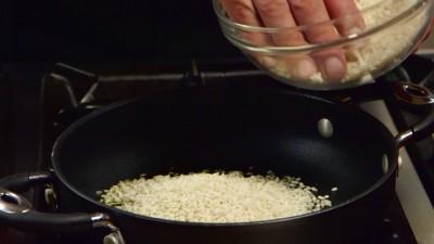 5 In una casseruola a parte, o meglio una risottiera, versate un giro d'olio extravergine d'oliva e versatevi il riso che dovrà tostare.