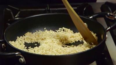 Fate tostare il riso a fuoco vivace fino a che i chicchi non diventeranno traslucidi, dovrete prestare molta attenzione nel mescolare continuamente il riso in modo tale da evitare che si