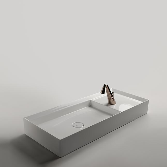 Un lavabo scultoreo costituito dalla giustapposizione di due forme finite e complementari: l incavo del bacino e il piano d appoggio rialzato.