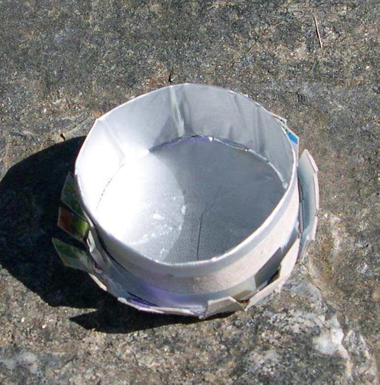 A paper clip holder made as shown in the two photos on the right, that is, with a cylinder base made of cardboard and covered with tinfoil.