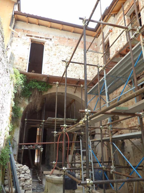 finestra; il secondo, con imbotto in pietra, arco a sesto ribassato e portone in legno con specchiature diamantate, è l attuale ingresso all androne archivoltato che da sul cortile comune dell