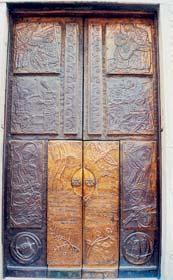i simboli di San Pietro: le chiavi e la mitra. Racchiude (fig. 5) la Porta in rame rossa smaltata, realizzata da padre Tarcisio Manta. I figura.