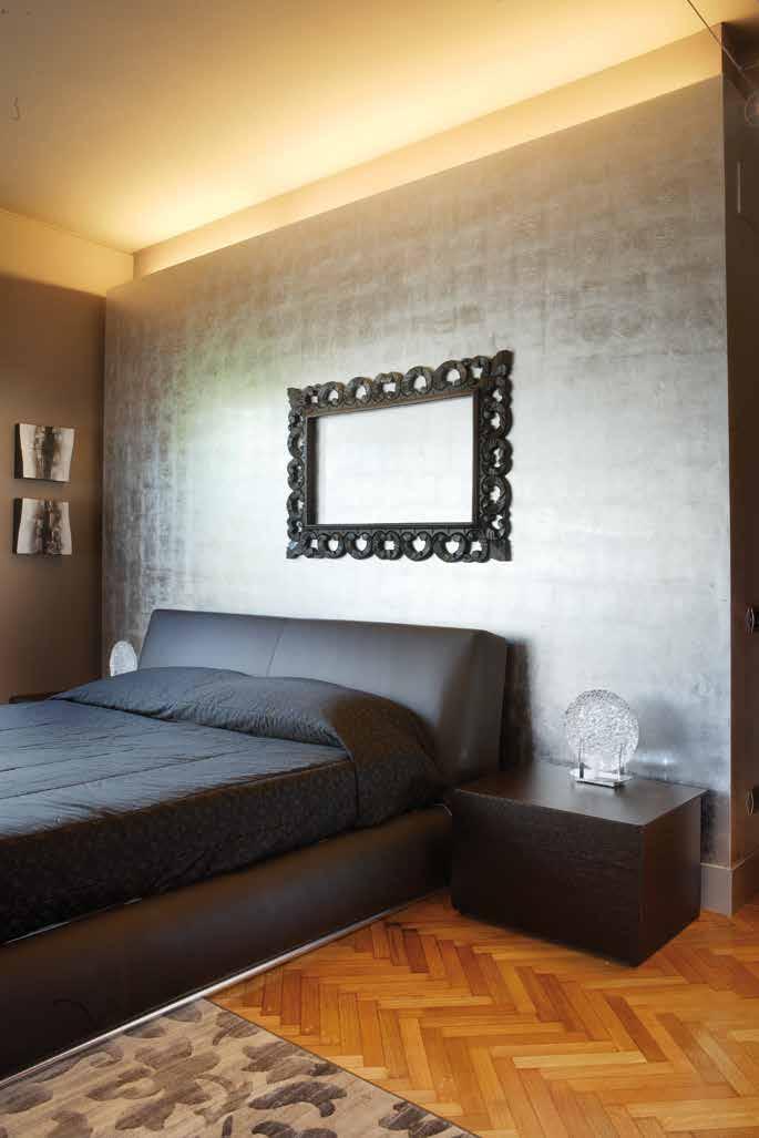A sinistra: il tortora carico delle pareti della camera da letto si illumina di riflessi lucenti grazie alla cassettiera in foglia argento.