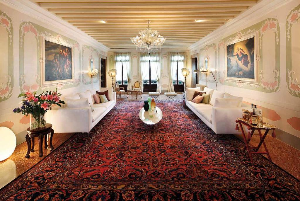Sul pavimento originale, in seminato nei vari toni del giallo, il tappeto annodato Lilian Persiano ospita i divani Easey di Arketipo in tessuto bianco, fronteggianti il tavolino ovale, design Charles
