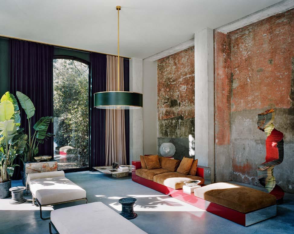 Nel living, le pareti conservano i pigmenti originali. Vincenzo De Cotiis ha scelto una lacca bordeaux per il divano, che riprende le tonalità rossastre dei muri.