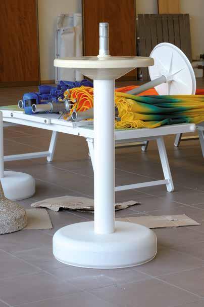 Beach umbrellas holder with table in plastic material.