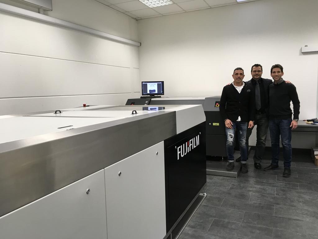 Figura 1 - Fiorenzo Fenu, Denny Loi di FLEXOSTUDIO insieme a Claudio Giacomelli di Synergic Solution davanti alla S928 di FUJI e al CDI 4835 di ESKO Il mercato di riferimento di Flexostudio richiede