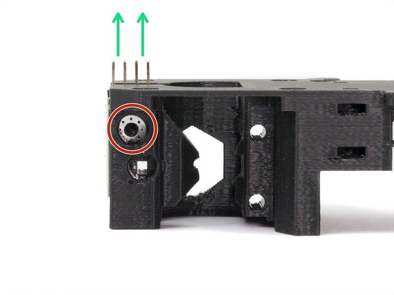 Step 9 Assemblaggio sensore filamento (parte 4) Gira il corpo estrusore come in immagine. I piedini del sensore devono essere rivolti verso l'alto. Localizza l'apertura per la vite M3.