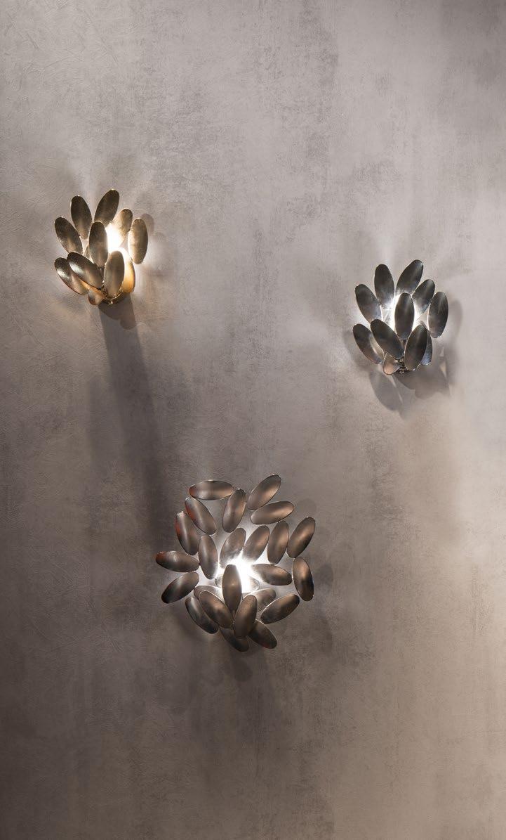 Sculptural steel wall lamp made with craft-welded leaf-shaped decorations. It comes in two different versions. Finishes: galvanised nickel, galvanised polished 24 K gold. Opaline glass cylinder.