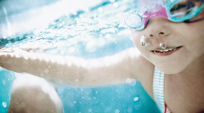 Il bambino gioca in acqua poco profonda (altezza dei