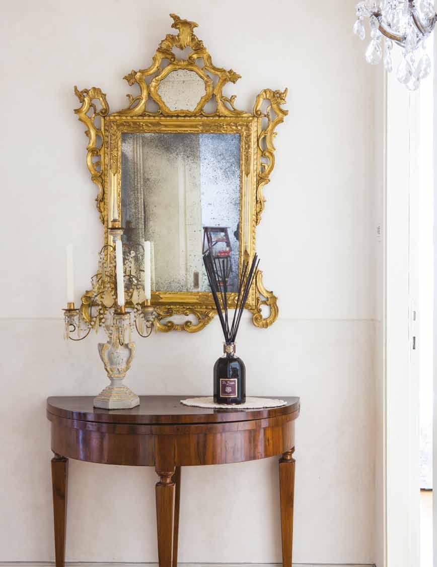 Nel corridoio che conduce alle camere, sulla consolle in legno, un profumatore d ambiente firmato Dr. Vranjes, una girandole d antan ed uno specchio barocco.