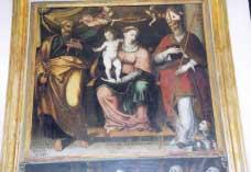 Sul trono è la Vergine che sorregge sulla gamba destra in piedi il Bambino nudo benedicente. Due angeli incoronano la Madre, fiancheggiata (a destra) for- figura. 10 se da S.