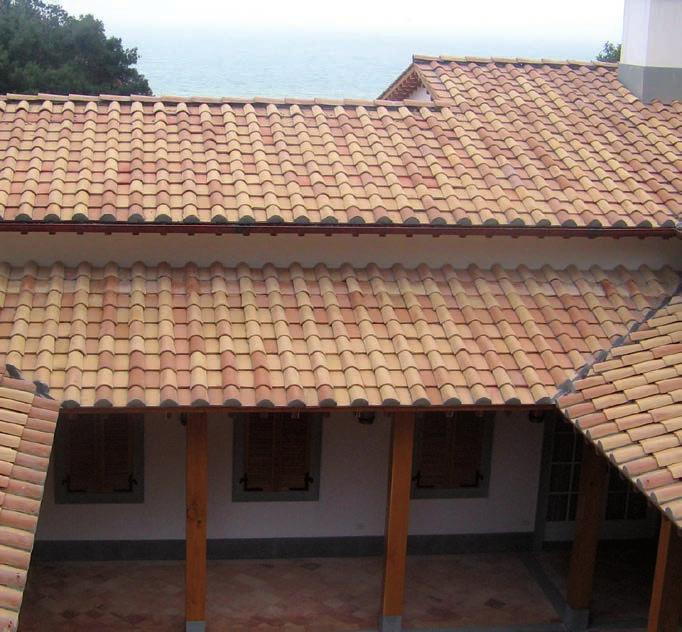 All interno, un cielo di capriate e travetti in legno, raccordati dalla calda protezione di un riparo in cotto artigianale. Più che architettura, un esperienza emozionale.