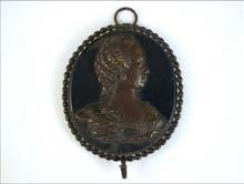 Lotto n. 091 - Dama su medaglione dama di profilo in bronzo a rilievo su fondo ovale in marmo nero, modanatura a perlinato, aggancio ad anello.